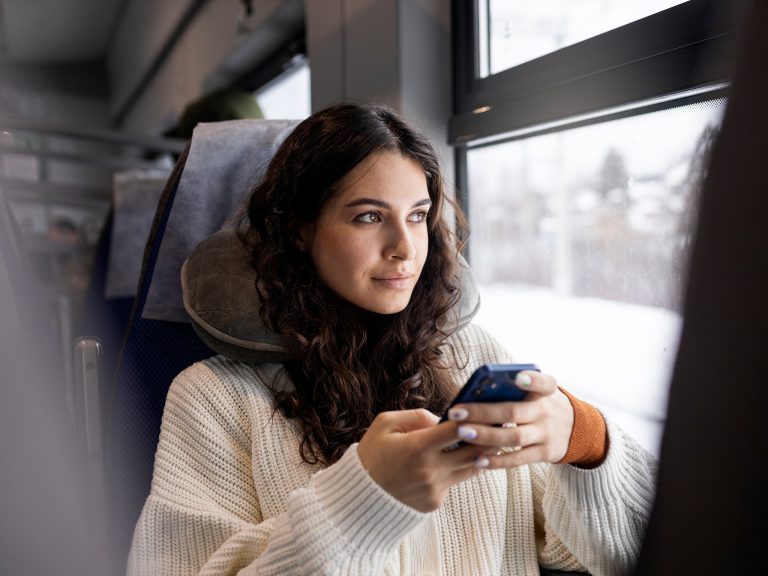 mujer-joven-usando-su-telefono-inteligente-mientras-viaja-tren